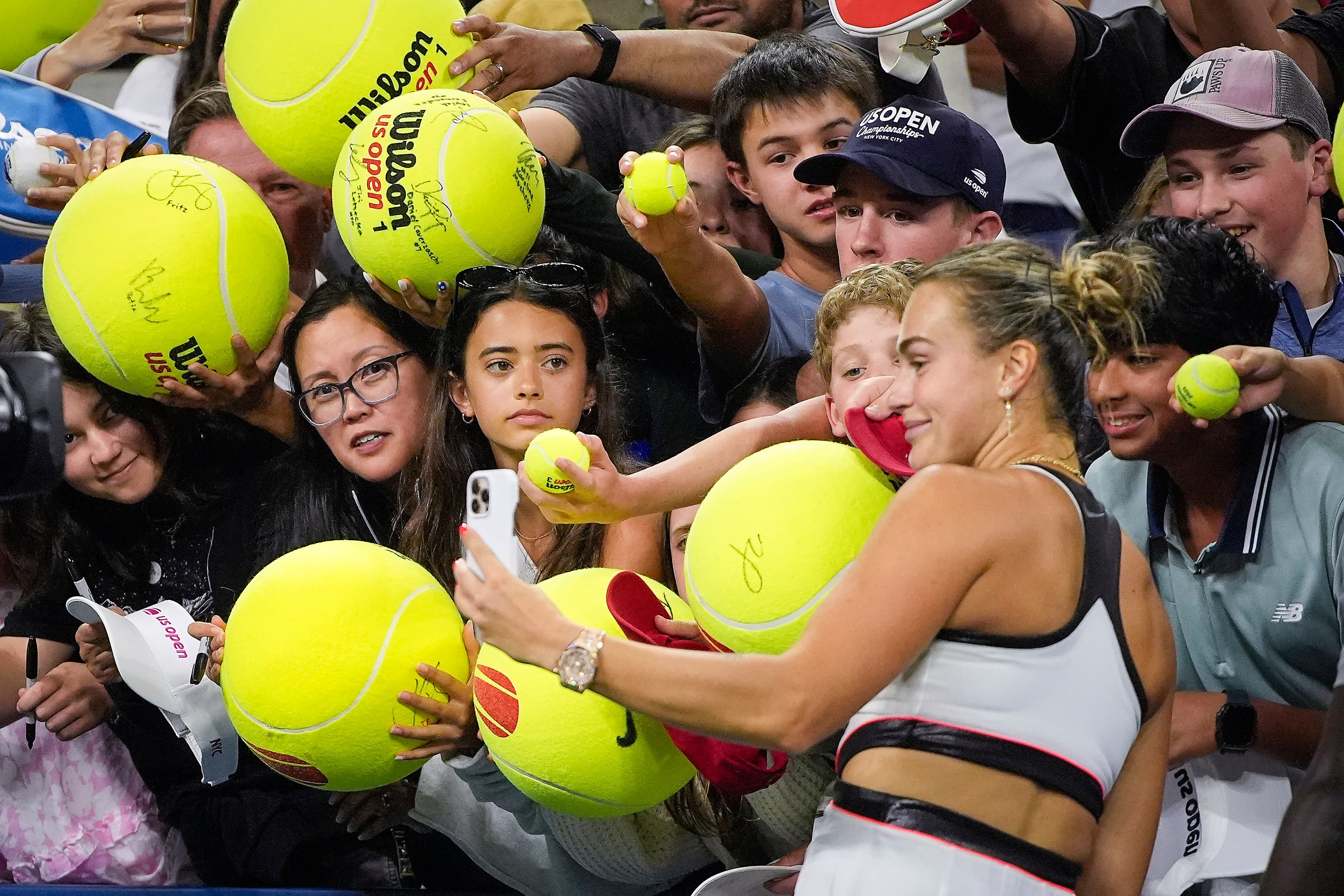 Aryna Sabalenka, of Belarus, takes photos with fans after defeating Cristina Bucsa, of Spain, during the fourth round of the US Open tennis championships, Sunday, Aug. 31, 2025, in New York